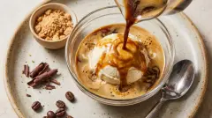 A close-up shot showing vanilla ice cream melting into dark espresso in a glass.