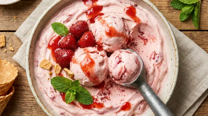 Perfectly scooped homemade strawberry ice cream in a cone.